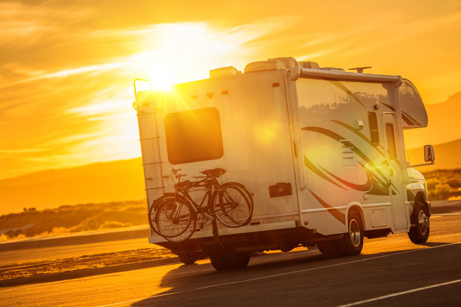 RV with bikes driving into sunset